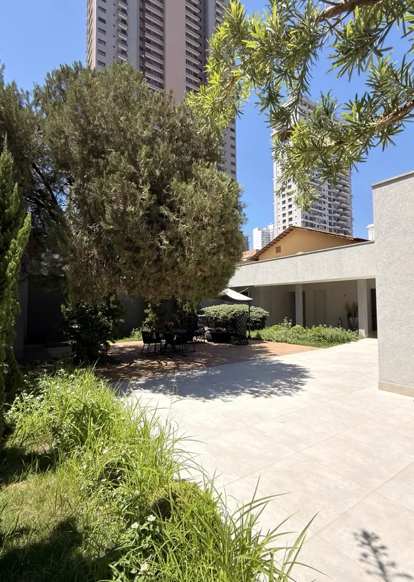 Entrada do espaço com árvores e jardim