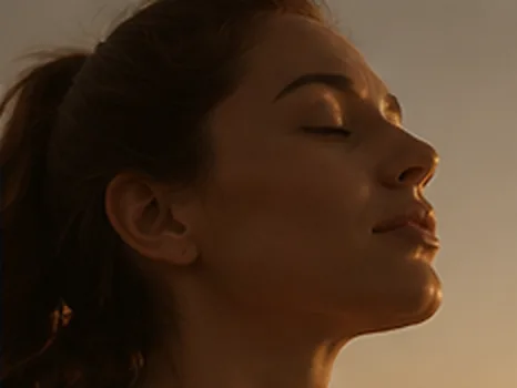 Mulher de olhos fechados sob a luz do sol